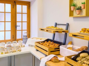 Un buffet de petit-déjeuner avec des viennoiseries, du pain et du café.