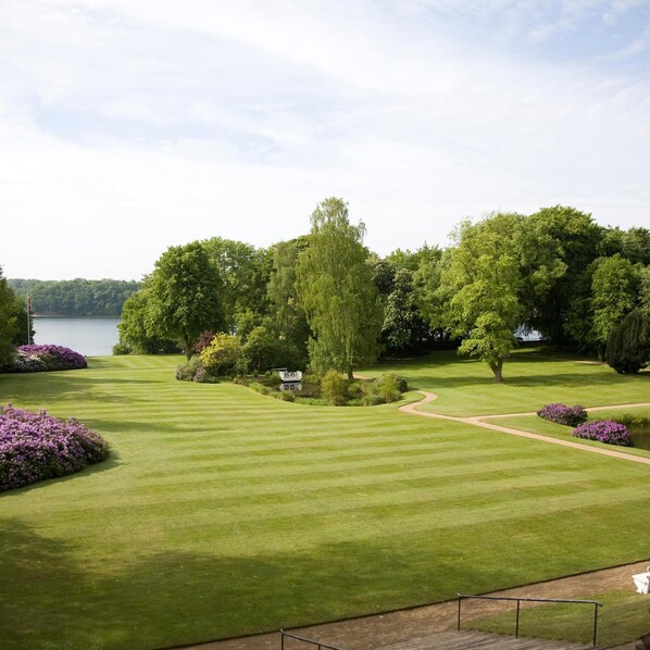 Un parcours de golf bien entretenu, offrant une vue dégagée sur un lac et une végétation luxuriante.