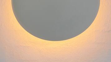 Una lámpara circular fijada a la pared, con el número 211 debajo.