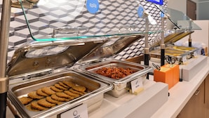 A buffet with labeled trays of turkey sausage, bacon, and other items. - Holiday Inn Express and Suites Oklahoma City Northwest by IHG (Oklahoma City)