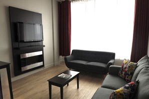 Suite, 1 King Bed with Sofa bed (Distinction) | Living area | 32-inch flat-screen TV with cable channels, TV - Travelodge by Wyndham Hotel & Convention Centre Quebec City (Québec City)