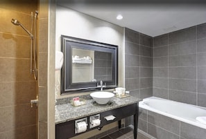 A modern bathroom with a large mirror, a sink, a bathtub, and a shower.