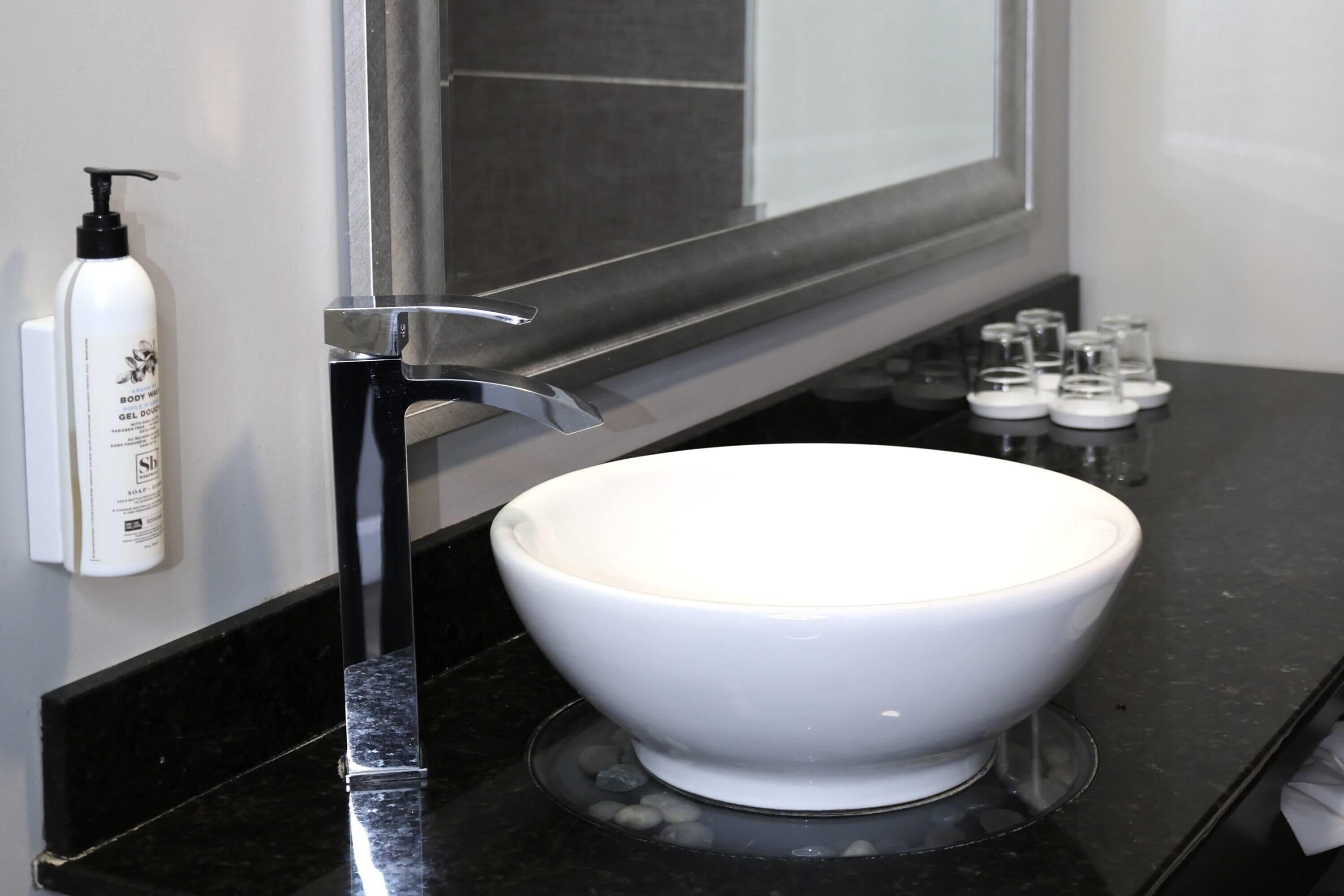 A bathroom with a white sink, a black faucet, and a mirror above the sink.