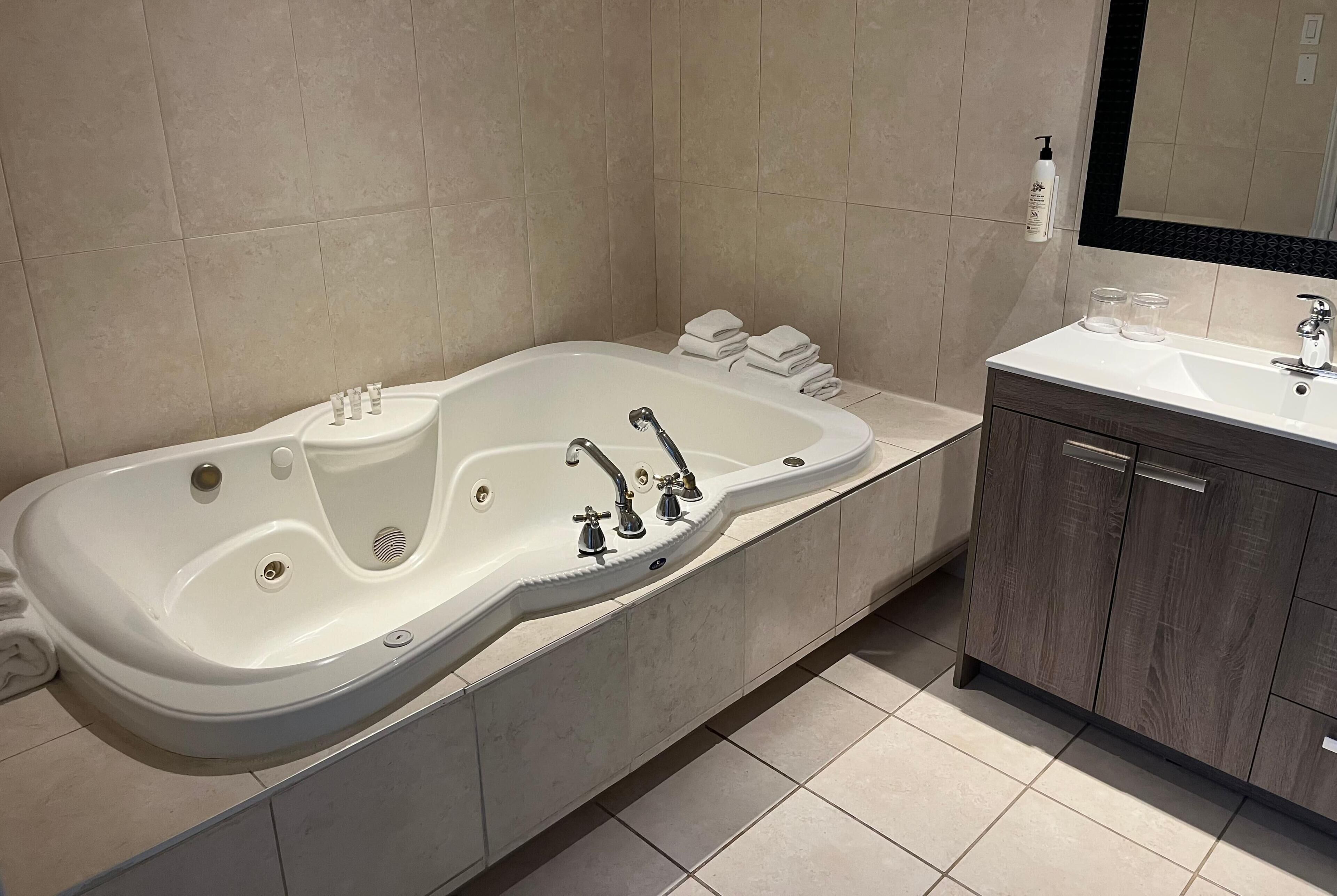 A modern bathroom with a freestanding bathtub, a vanity with a mirror, and a toilet.