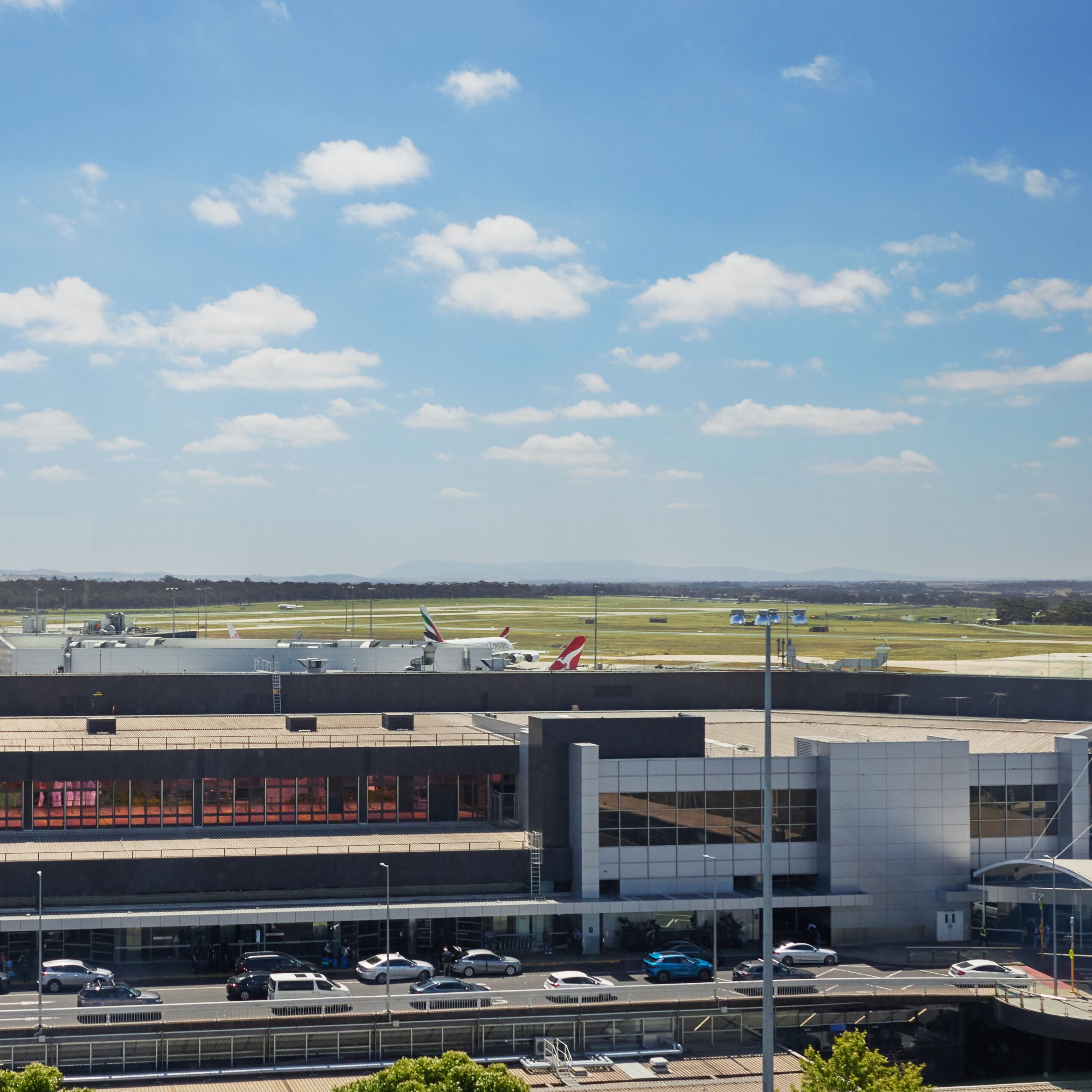 An airport terminal with a modern architectural design, featuring a multi-level structure with a glass facade.