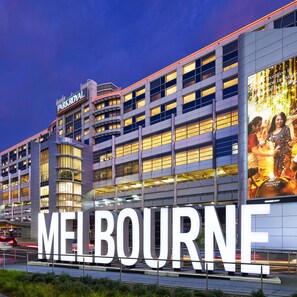 A large building with the word "MELBOURNE" prominently displayed on the facade.