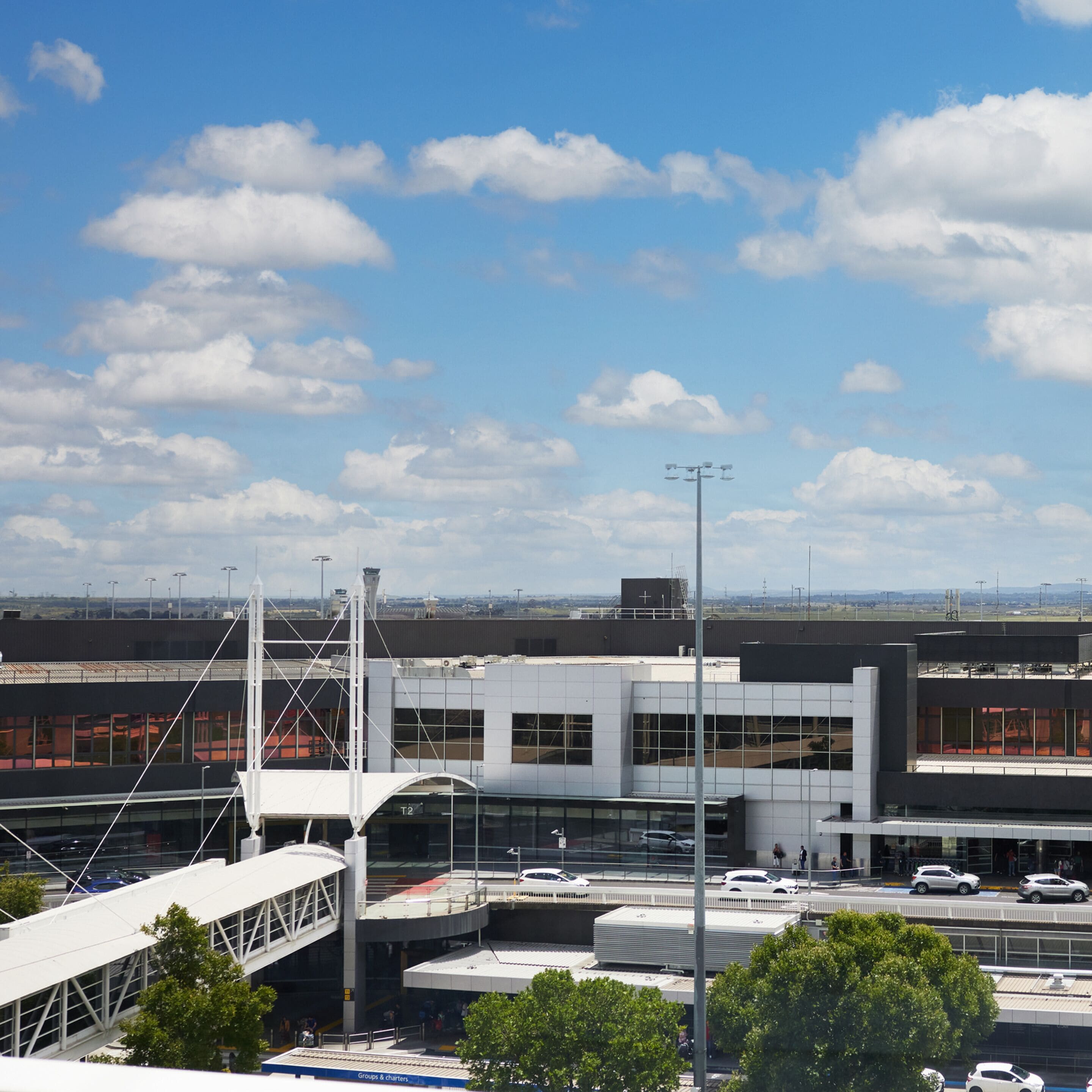 Un terminal d’aéroport moderne, avec un ciel dégagé et quelques nuages.