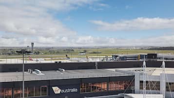 Una terminal de aeropuerto con un letrero de Virgin Australia, una torre de control y aviones en la plataforma.