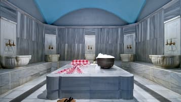 Relax in this spacious bathroom with a central sink and two ornate basins.