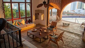 A spacious living area with a large window, a wooden coffee table, and comfortable seating. - Casa Lisa by Hoteles BF (Acapulco)