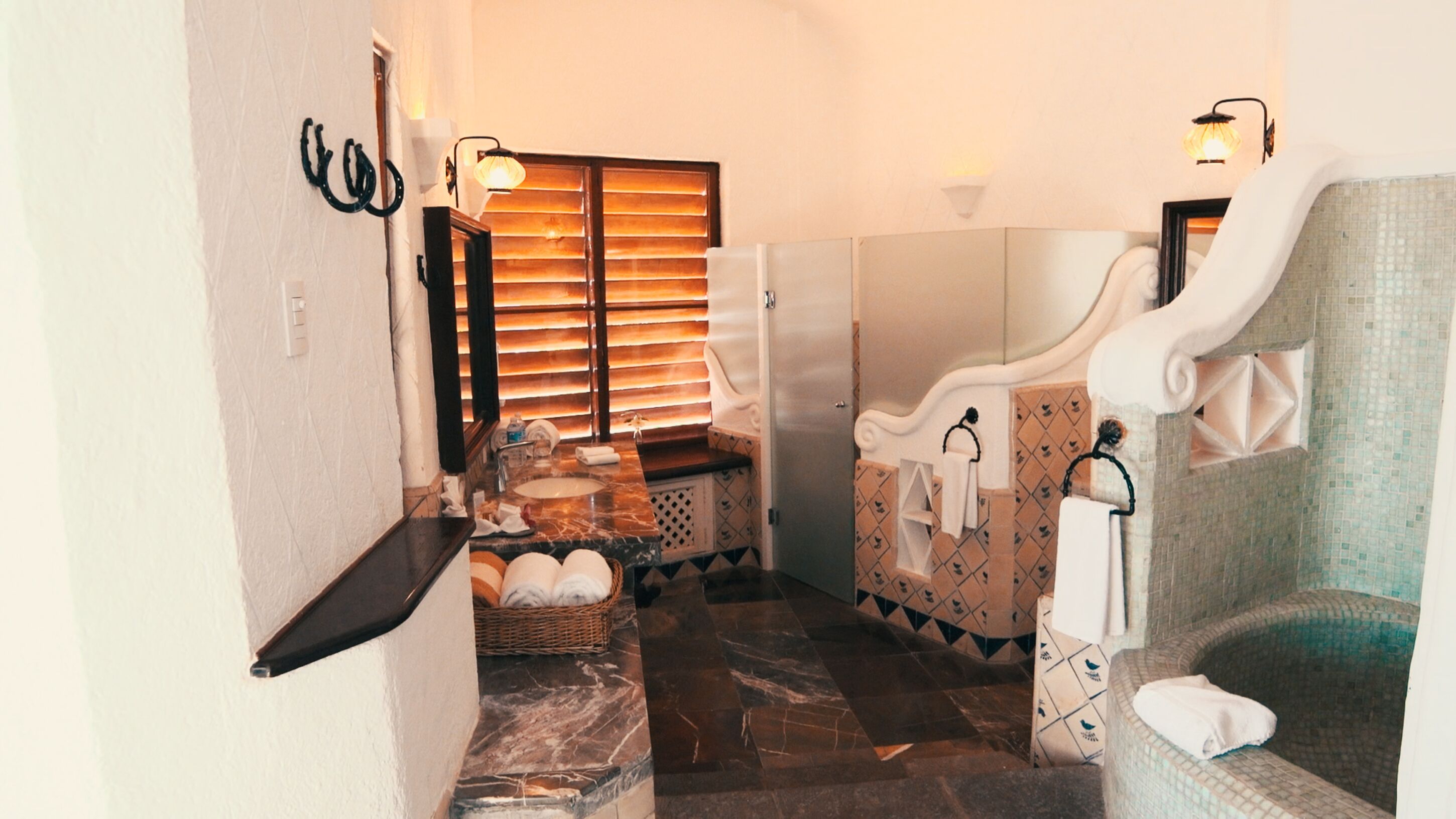Une salle de bain avec un sol en marbre, un lavabo, une baignoire et un espace douche.