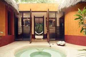 Un espacio de spa con un jacuzzi, una hamaca y toallas.