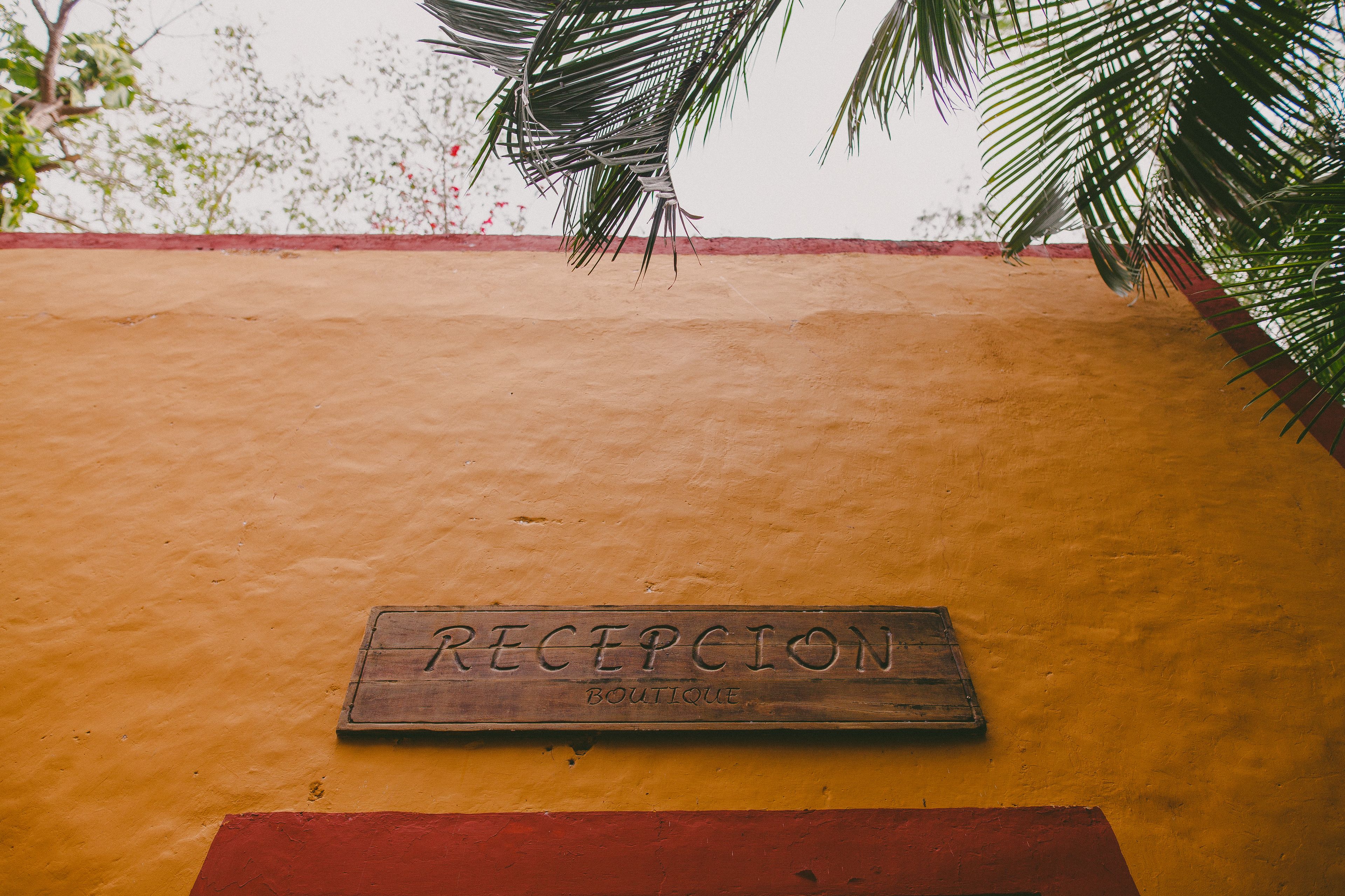 A reception sign on a yellow wall with a red border.