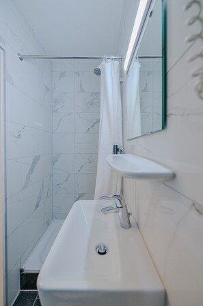 A bathroom with a white sink, a mirror, and a shower curtain.