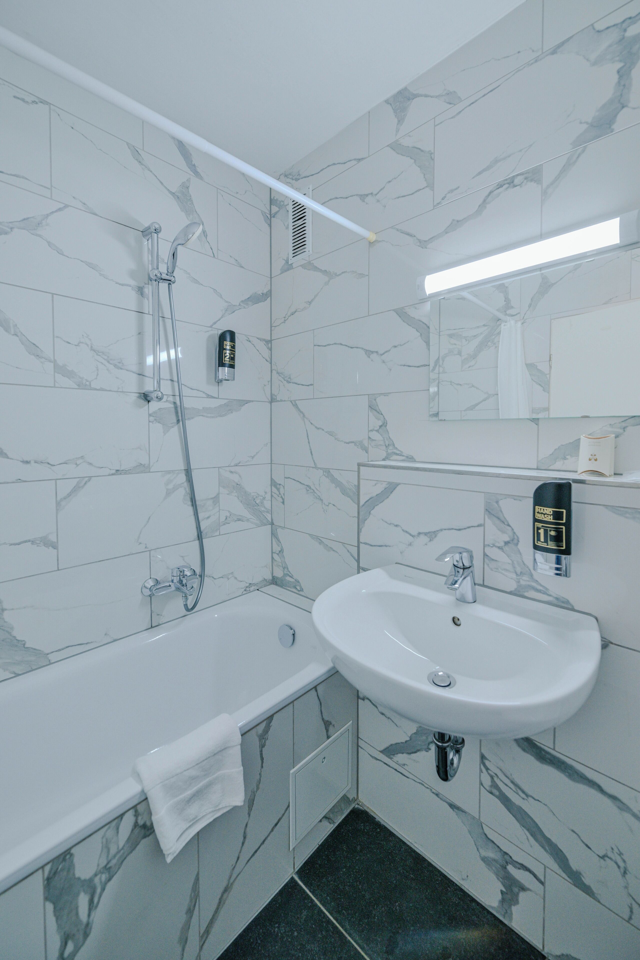 A modern bathroom with a bathtub, a sink, and a shower.