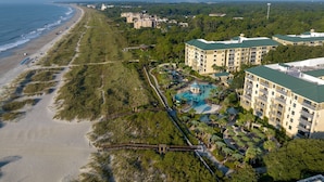 An aerial view of a coastal resort with beachfront properties, a swimming pool, and lush greenery. - Marriott's Barony Beach Club (Hilton Head Island)