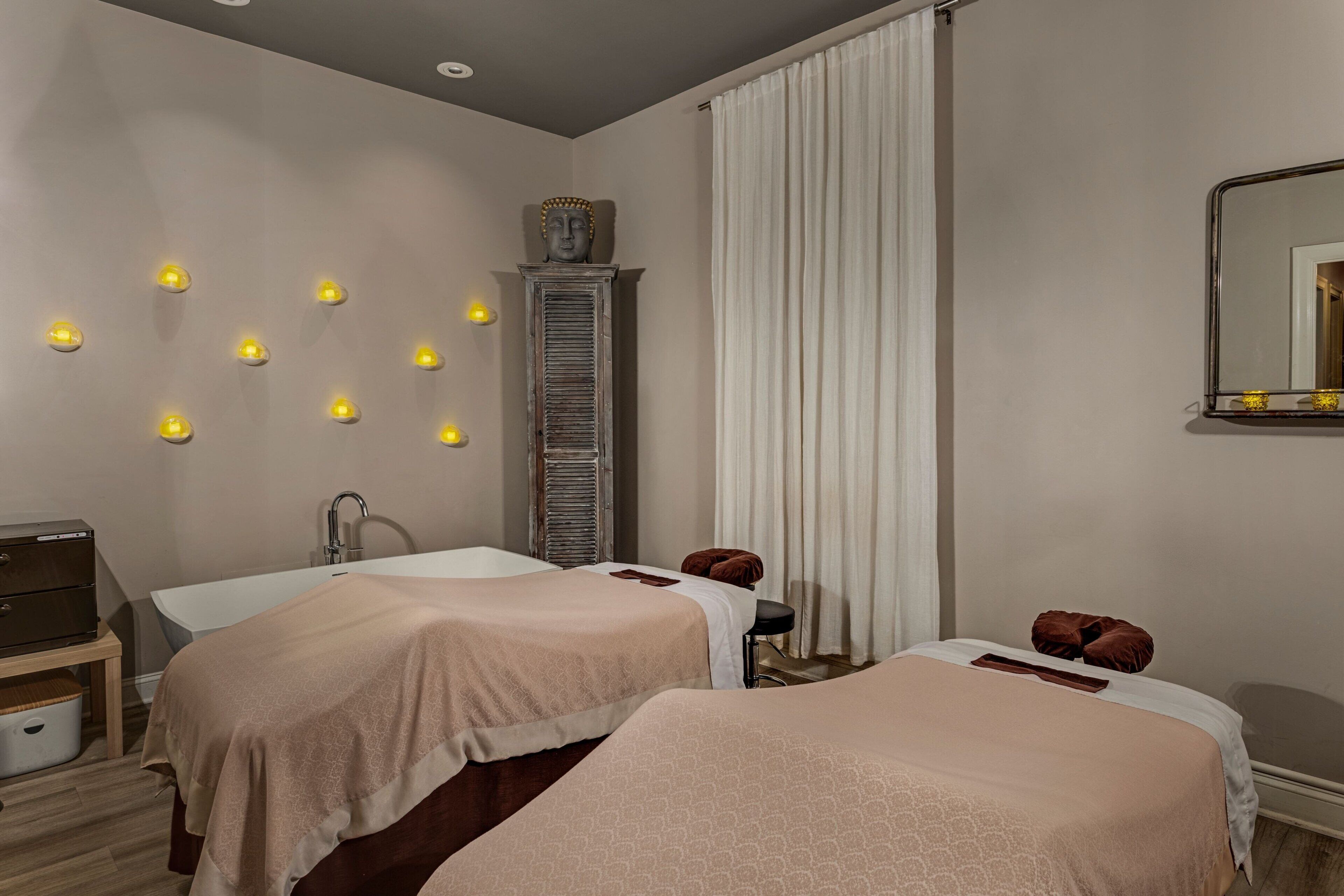 Une chambre d’hôtel avec deux lits, une coiffeuse et un miroir.