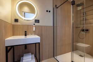 Familiekamer | Badkamer | Een douche, een haardroger, handdoeken