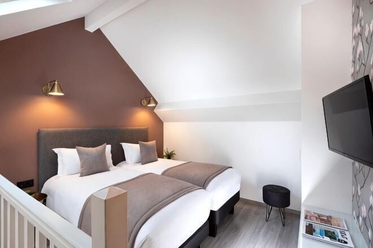 Een slaapkamer met twee bedden, een televisie en een tijdschriftrek.