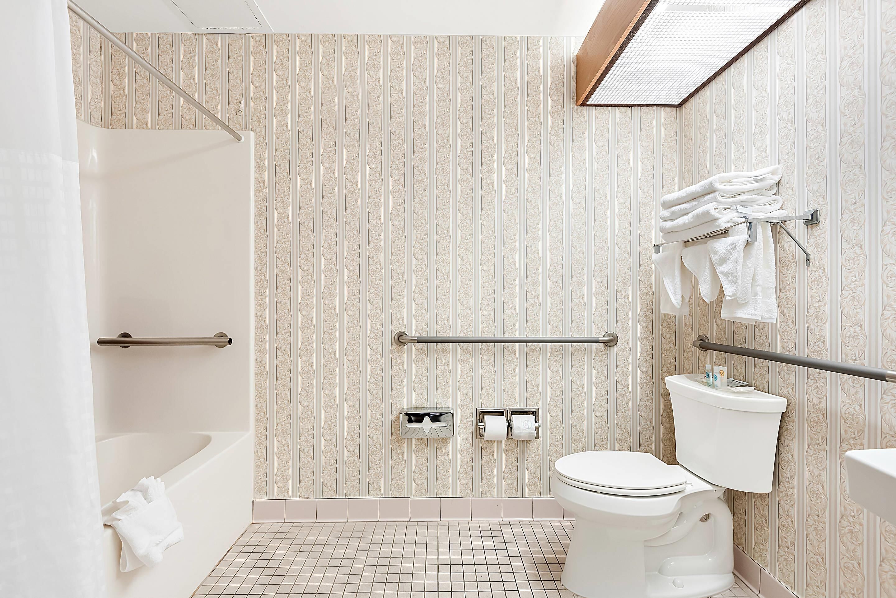 Ein Badezimmer mit Dusche, Toilette und Handtuchhalter.
