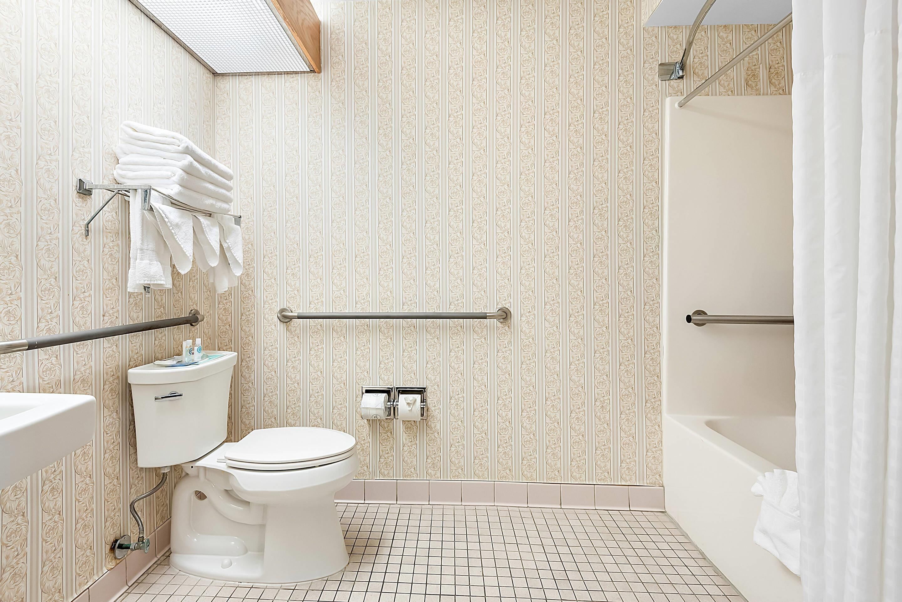 Een badkamer met toilet, wastafel en bad.