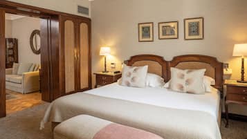 Ein Hotelzimmer mit einem großen Bett, zwei Nachttischen, einem Schrank, einem Spiegel und einem Sofa.