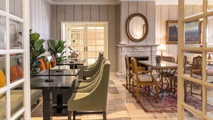 A dining area with a fireplace, a large mirror, and a view of the dining room through a glass door. - Hotel Lisboa Plaza, a Lisbon Heritage Collection (Lisbon)