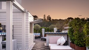 A modern outdoor patio with a sofa and cushions, a barbecue area, and a view of the sky. - Hotel Lisboa Plaza, a Lisbon Heritage Collection (Lisbon)