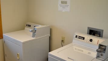 A laundry room with two front-loading washing machines and a dryer.