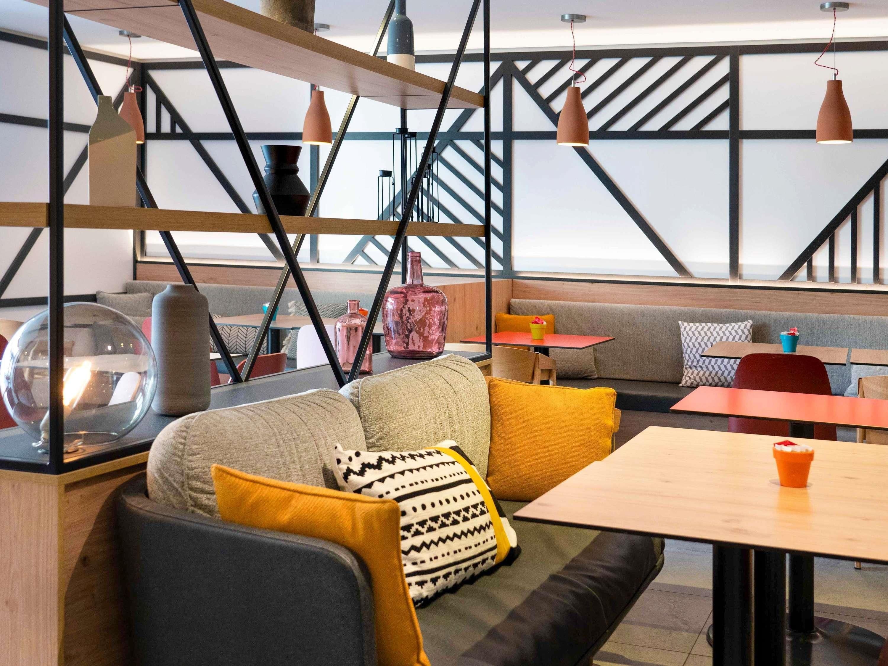 A modern interior with a sofa, cushions, a table, and hanging pendant lights.