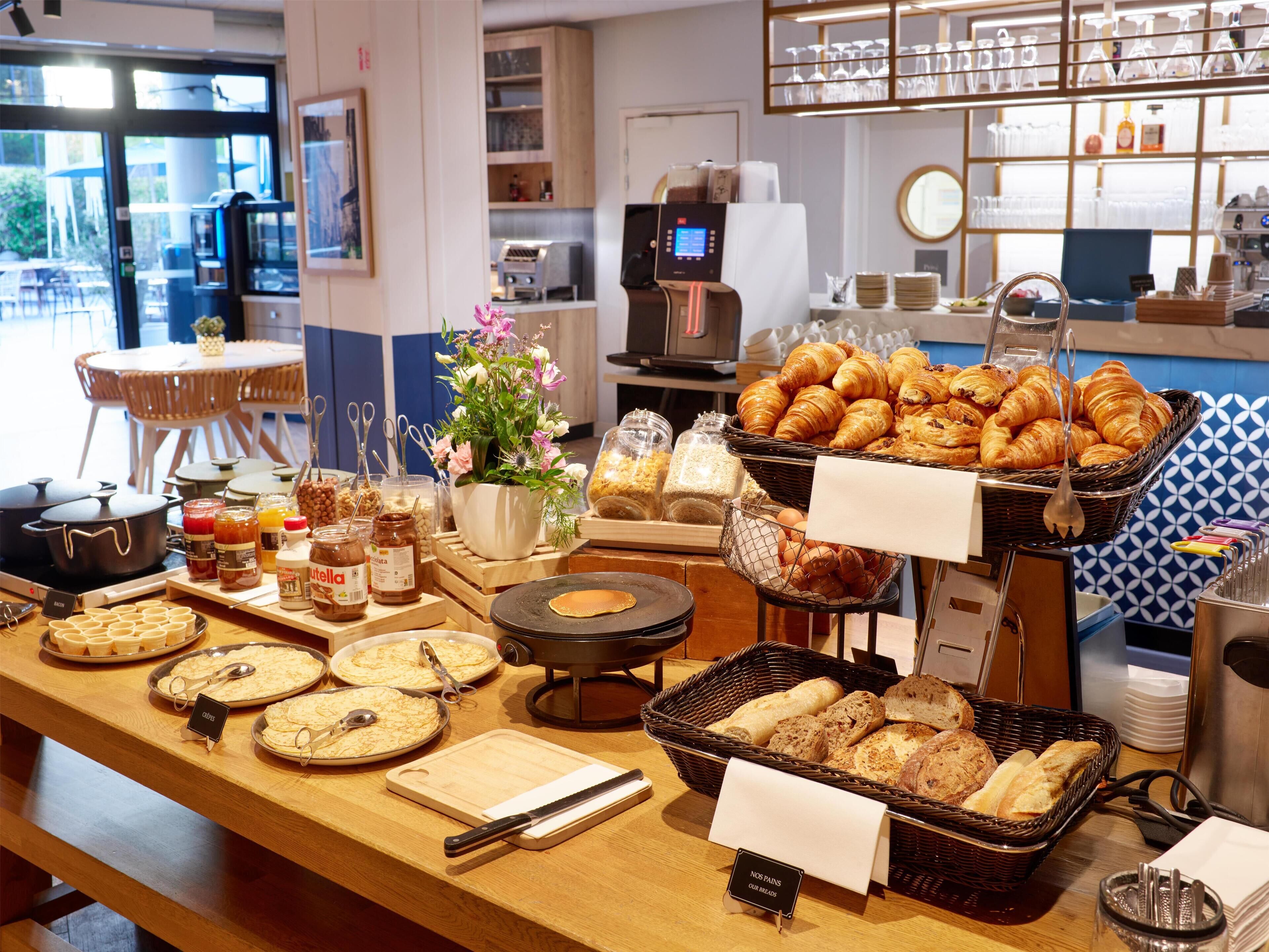 Un buffet proposant une variété de plats, notamment des pâtisseries, du pain et des condiments.