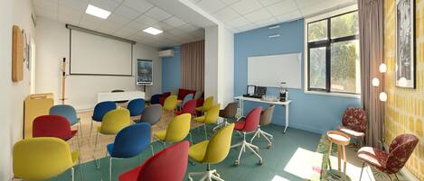 A conference room with colorful chairs, a projector, and a whiteboard.
