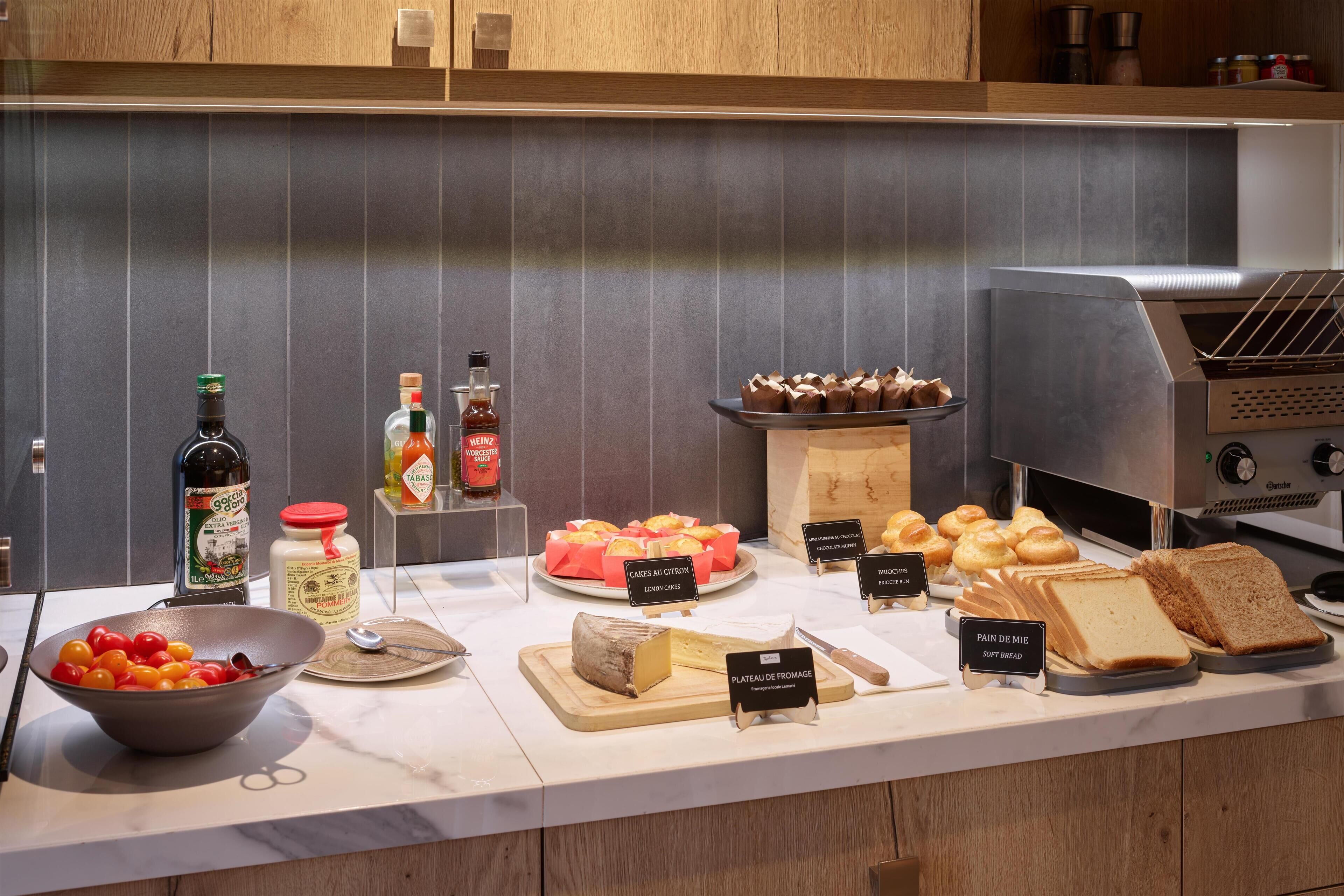 En buffet med forskellige spiser, herunder brød, ost og kager.