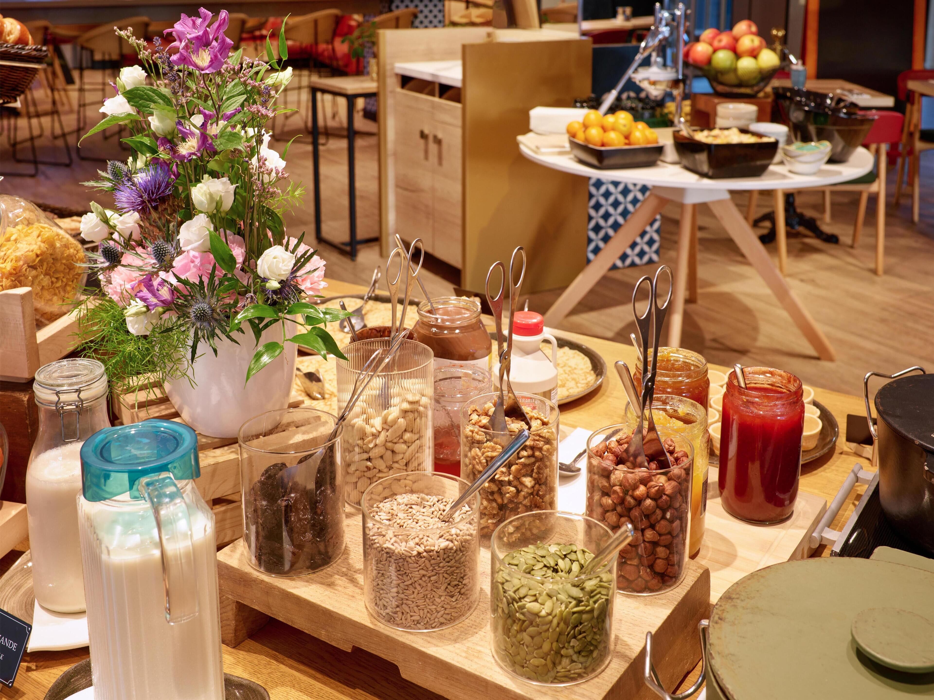 A buffet table with various food items and a floral centerpiece.