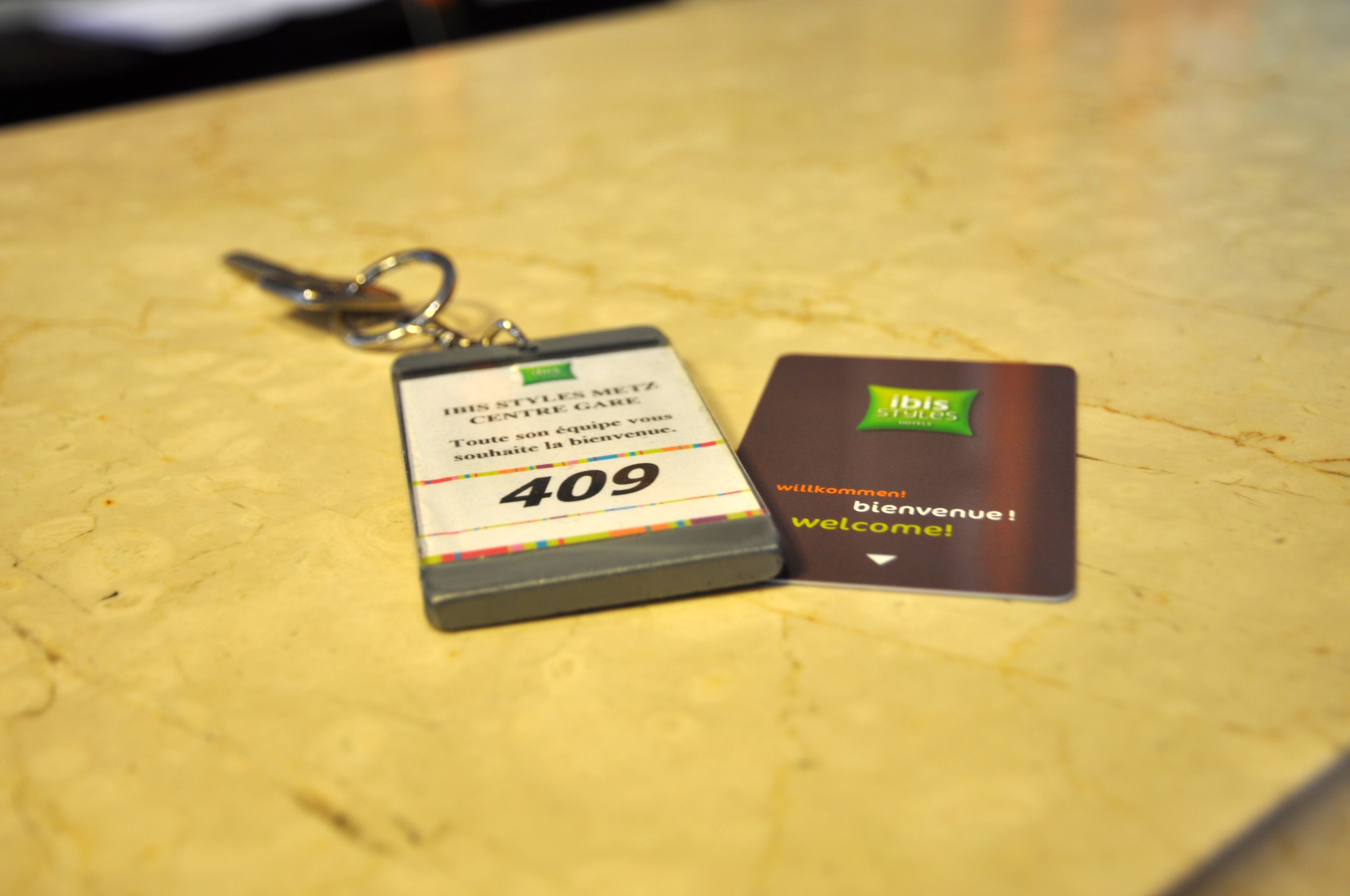 A keychain with a number tag and a business card on a marble surface.