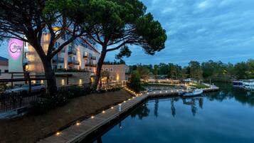 A waterfront hotel with a dock, a large tree, and a calm lake.