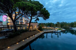 A waterfront hotel with a dock, a large tree, and a calm lake.