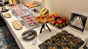 Een buffet met verschillende soorten eten, waaronder vlees, fruit en noten.