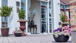 Een modern hotel met een opvallend 'PARK HOTEL' bord, grote ramen en plantenbakken voor de ingang.