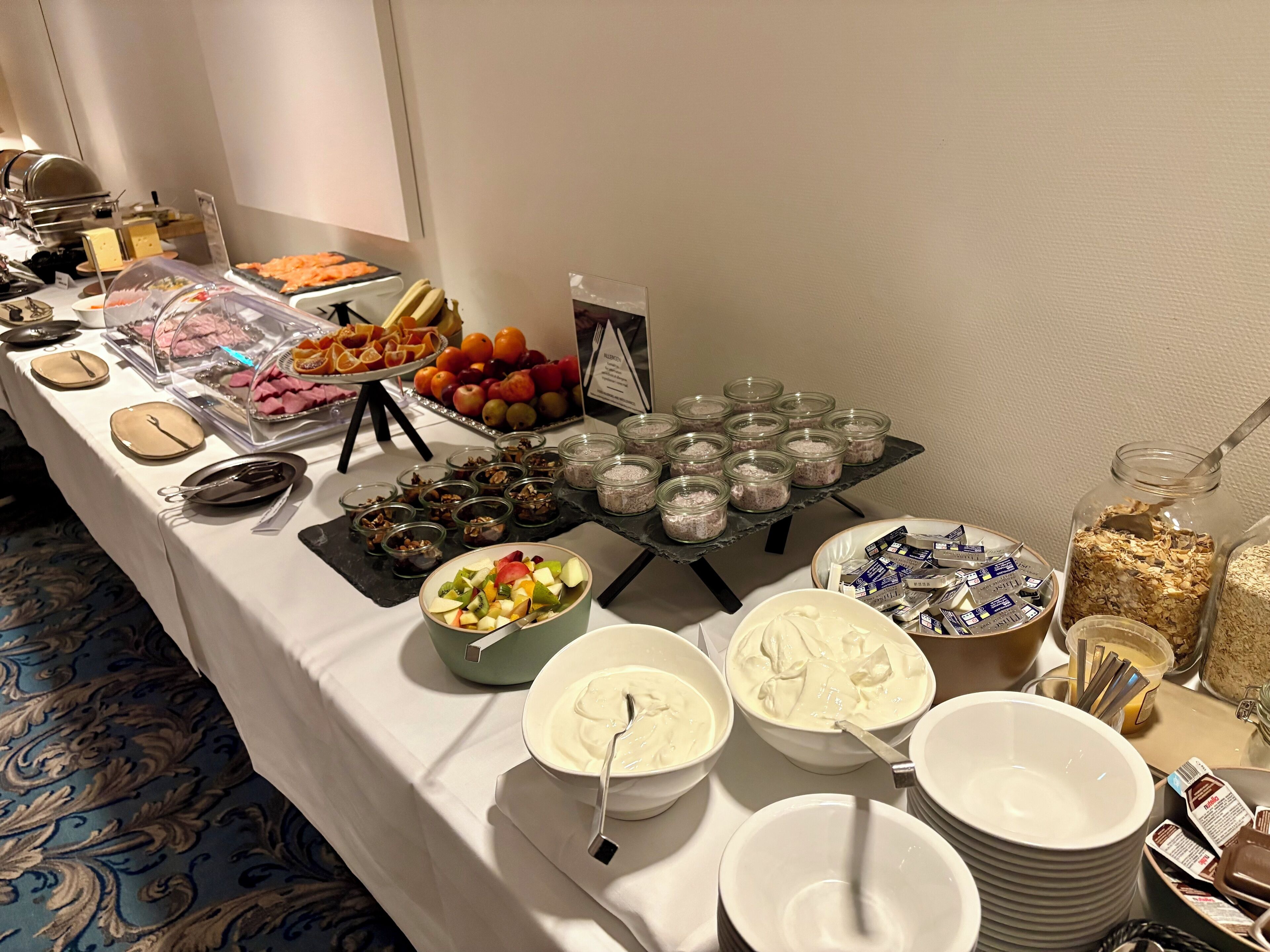 Una mesa de buffet con diferentes opciones de comida, como frutas, postres y bebidas.