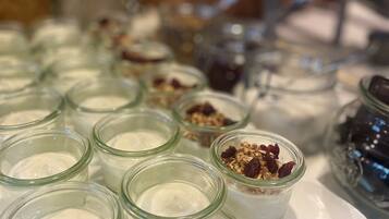 A tray of small glass jars containing various food items, likely for catering or serving.