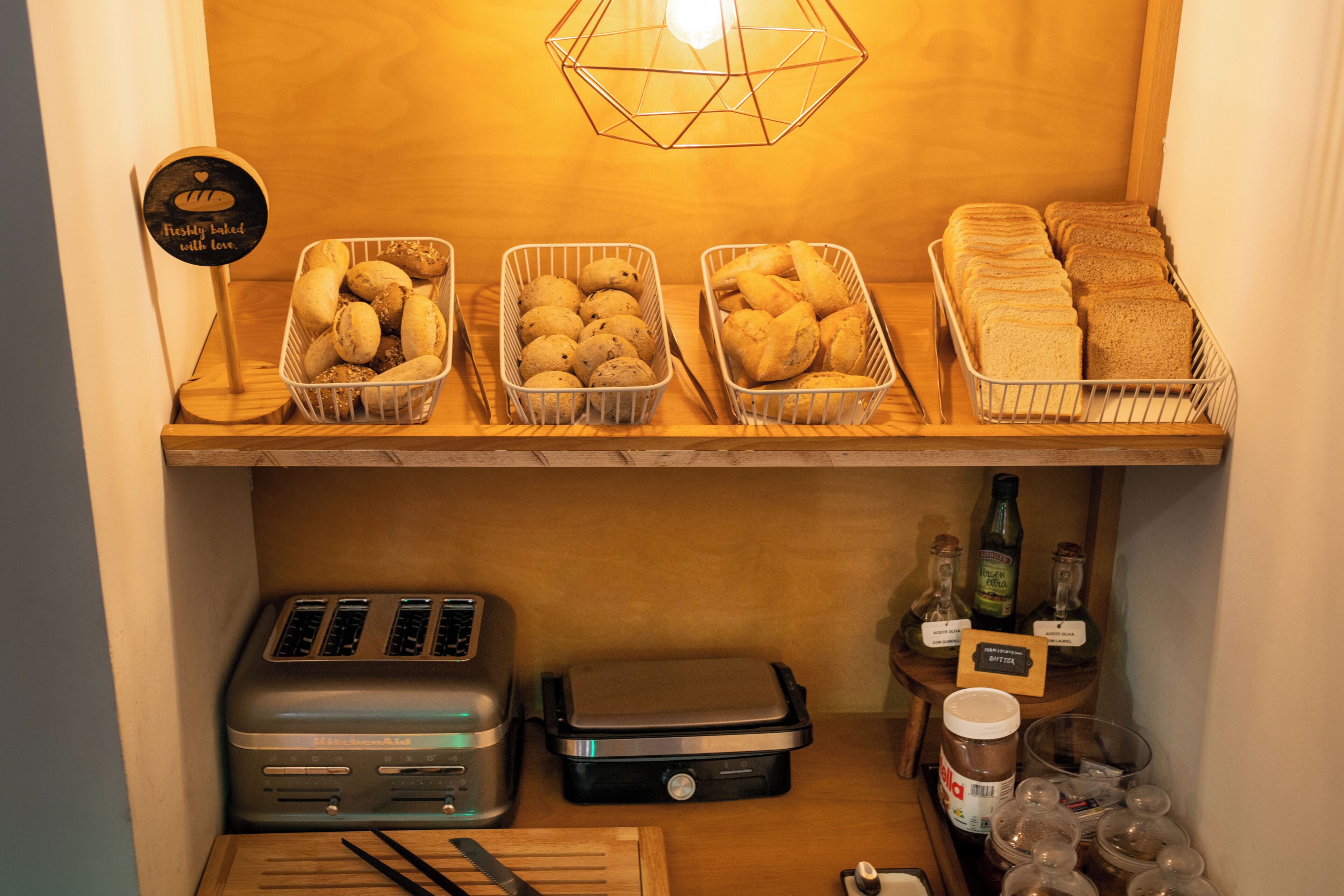 Una zona de cocina con cestas de pan, una tostadora y condimentos.