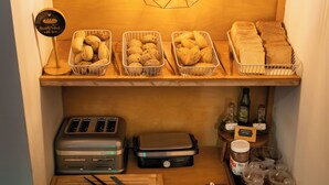 Una zona de cocina con cestas de pan, una tostadora y condimentos.