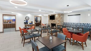A hotel lobby with multiple seating areas, a coffee station, and a fireplace. - Holiday Inn Express Hotel & Suites Chicago-Algonquin by IHG (Algonquin)