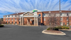 A Holiday Inn Express hotel with a brick facade, a covered entrance, and a parking lot.