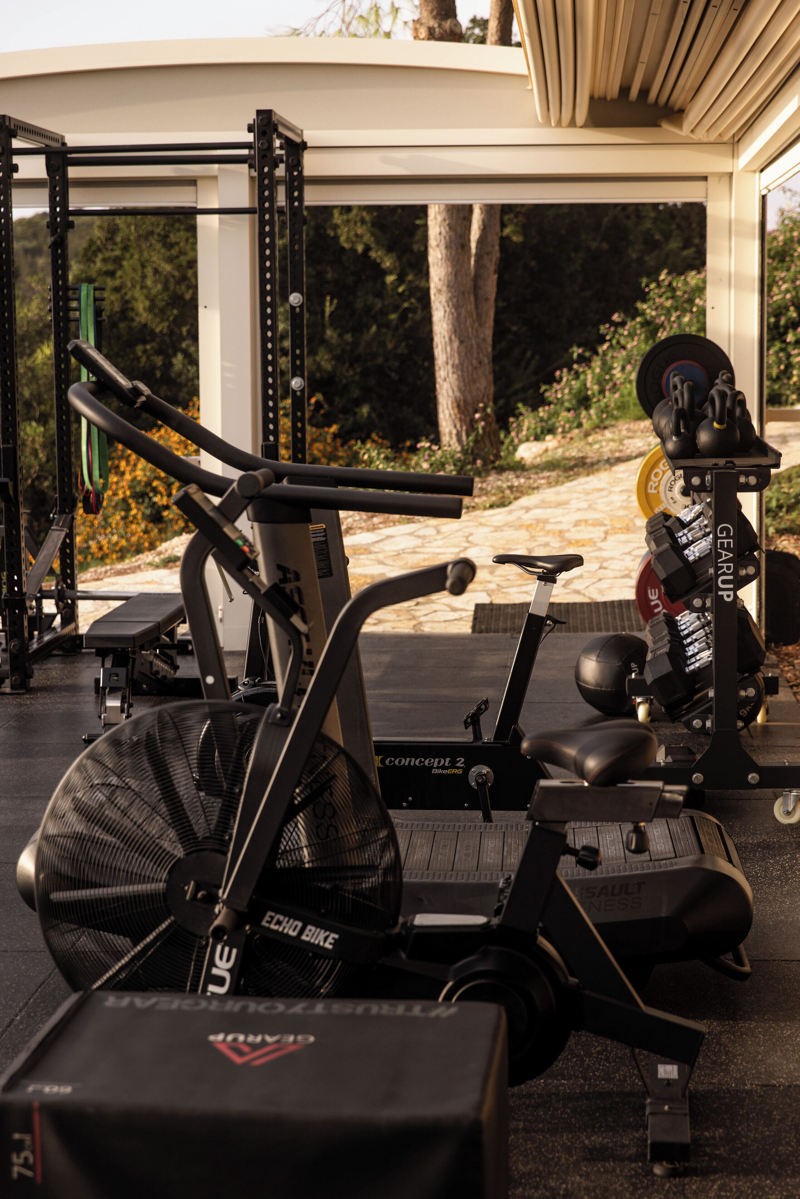 A home gym with exercise equipment, including a treadmill, stationary bike, and weight bench.