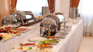 Una mesa de buffet con diferentes opciones de comida y estaciones de servicio.