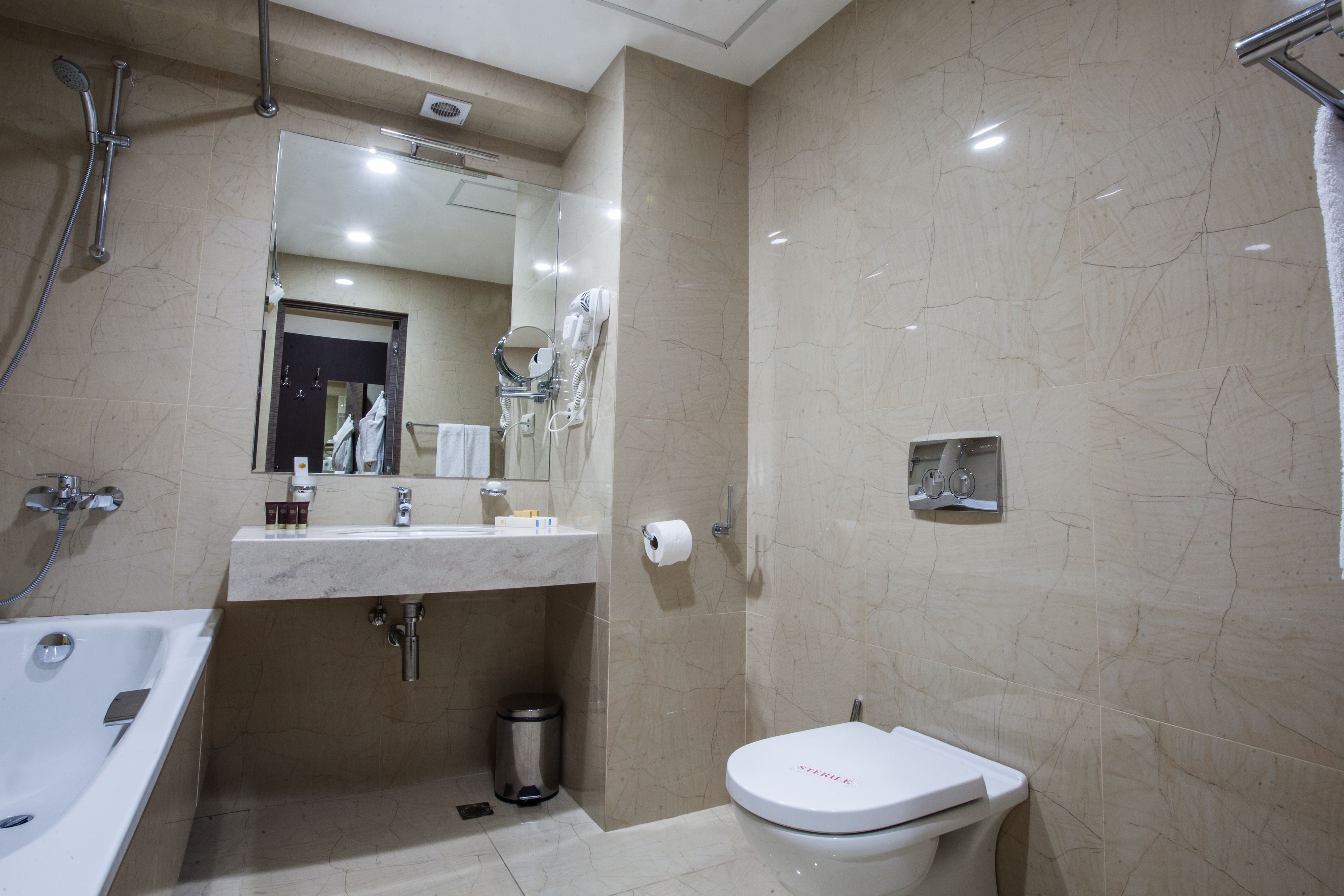 Un baño moderno con bañera, lavamanos e inodoro.