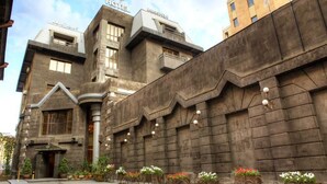 Un hotel con un diseño arquitectónico moderno, que destaca por una entrada con fachada curva e iluminación decorativa.