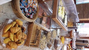 Ein Buffet mit verschiedenen Speisen, darunter Gebäck, Obst und Soßen.